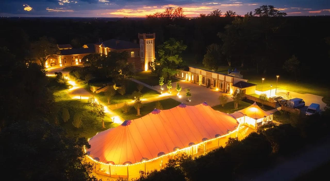 Château et chapiteau illuminés de l'Orangerie des Demoiselles au crépuscule